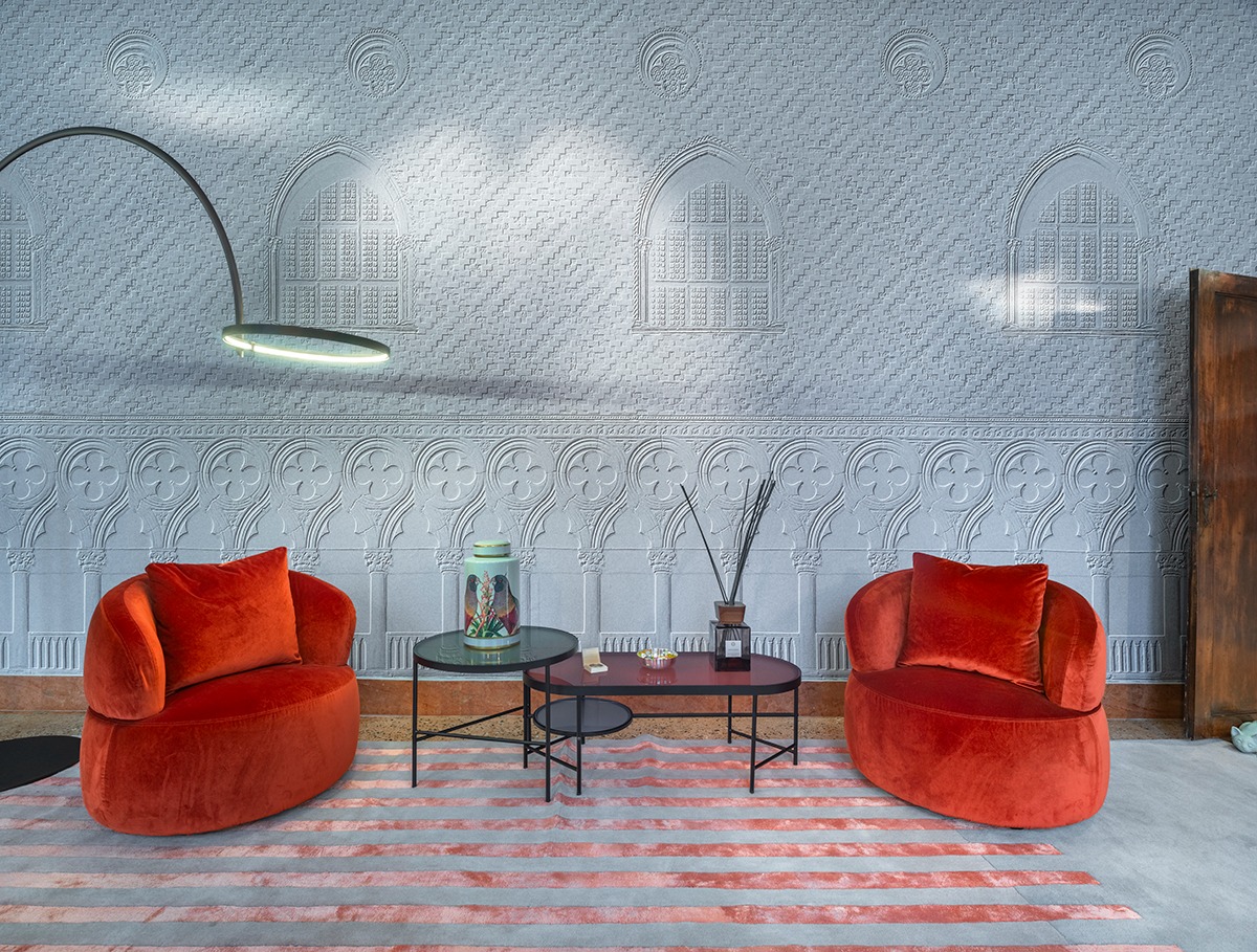 Poltrone rosse e wallpaper architettonico